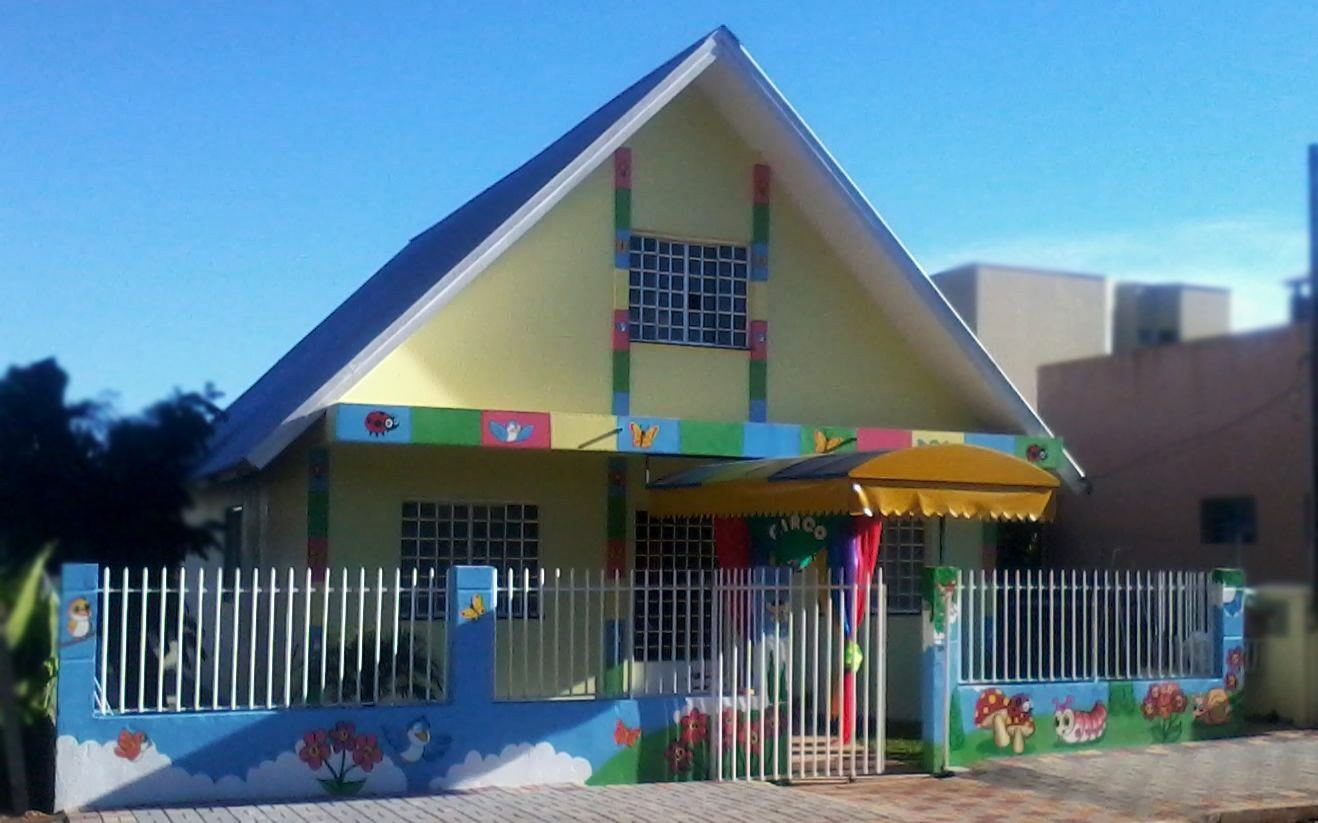 Casa de escola pintada com cores fortes na fachada e no muro
