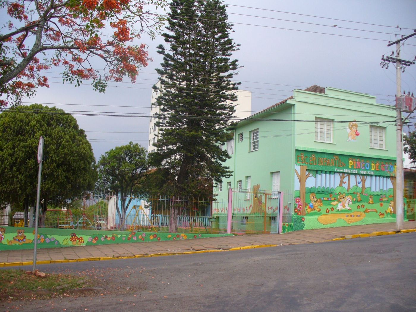 Prédio verde de escola infantil com muro pintado