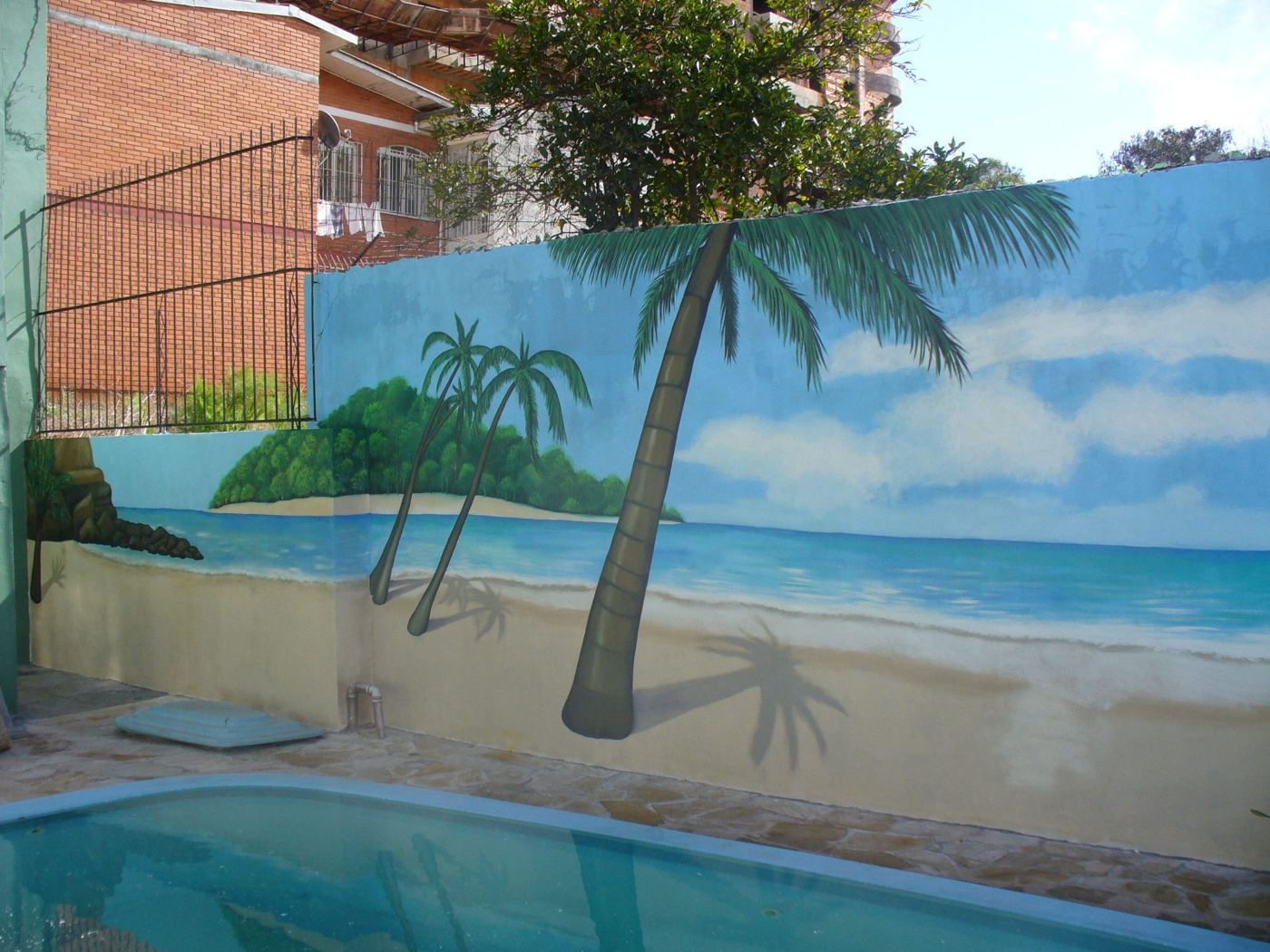 Muro de piscina pintado com praia, coqueiros e mar